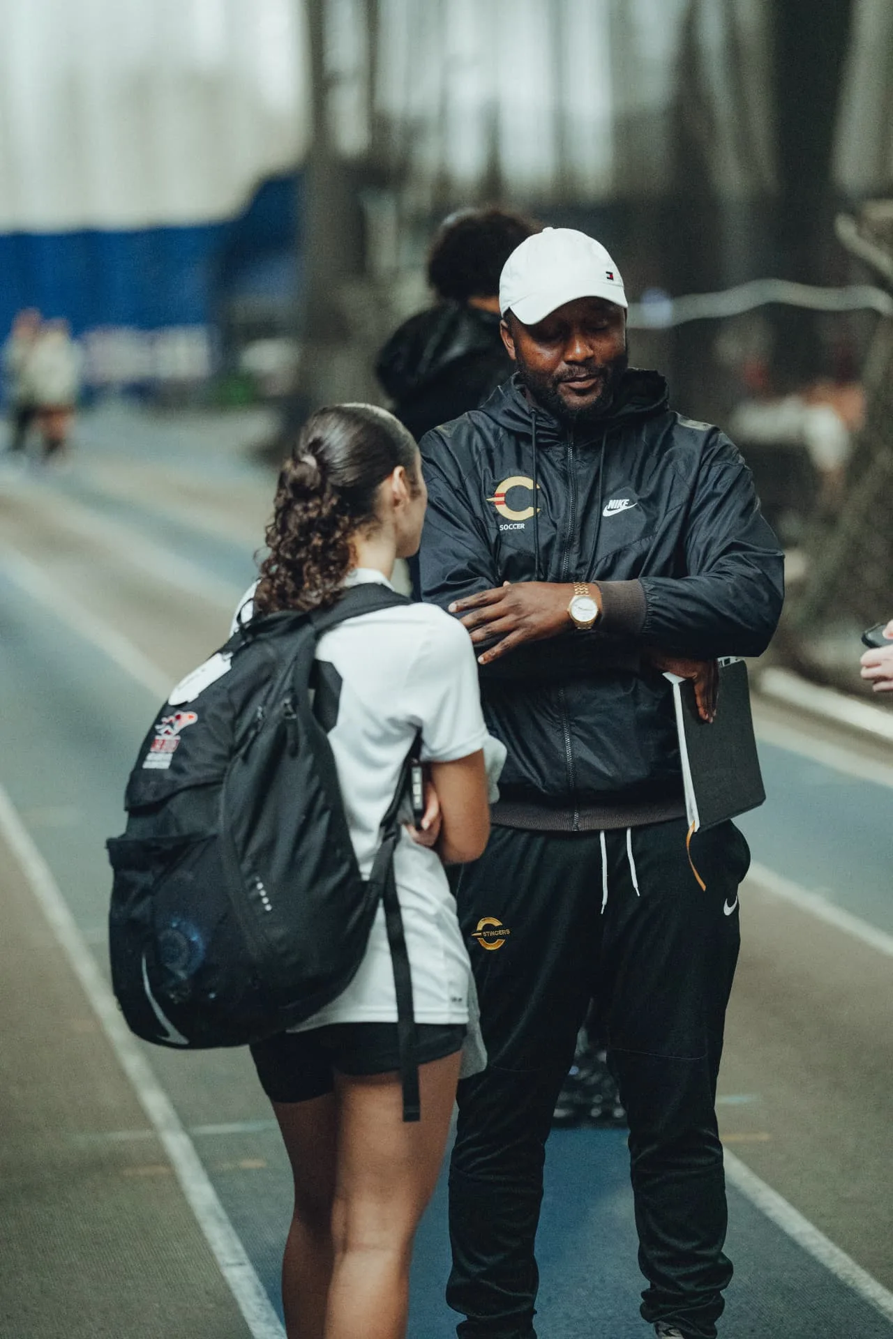 A college coach speaking with a player after an OPSM showcase