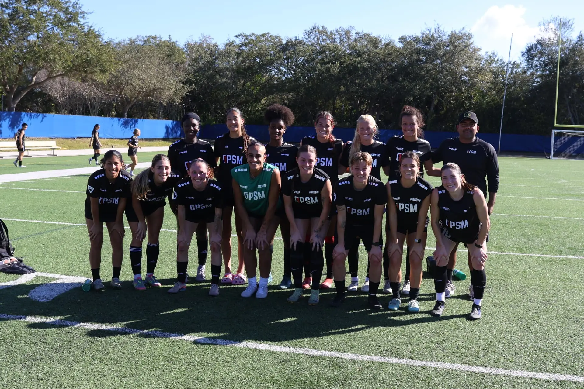 Team photo of the black squad with coaching staff