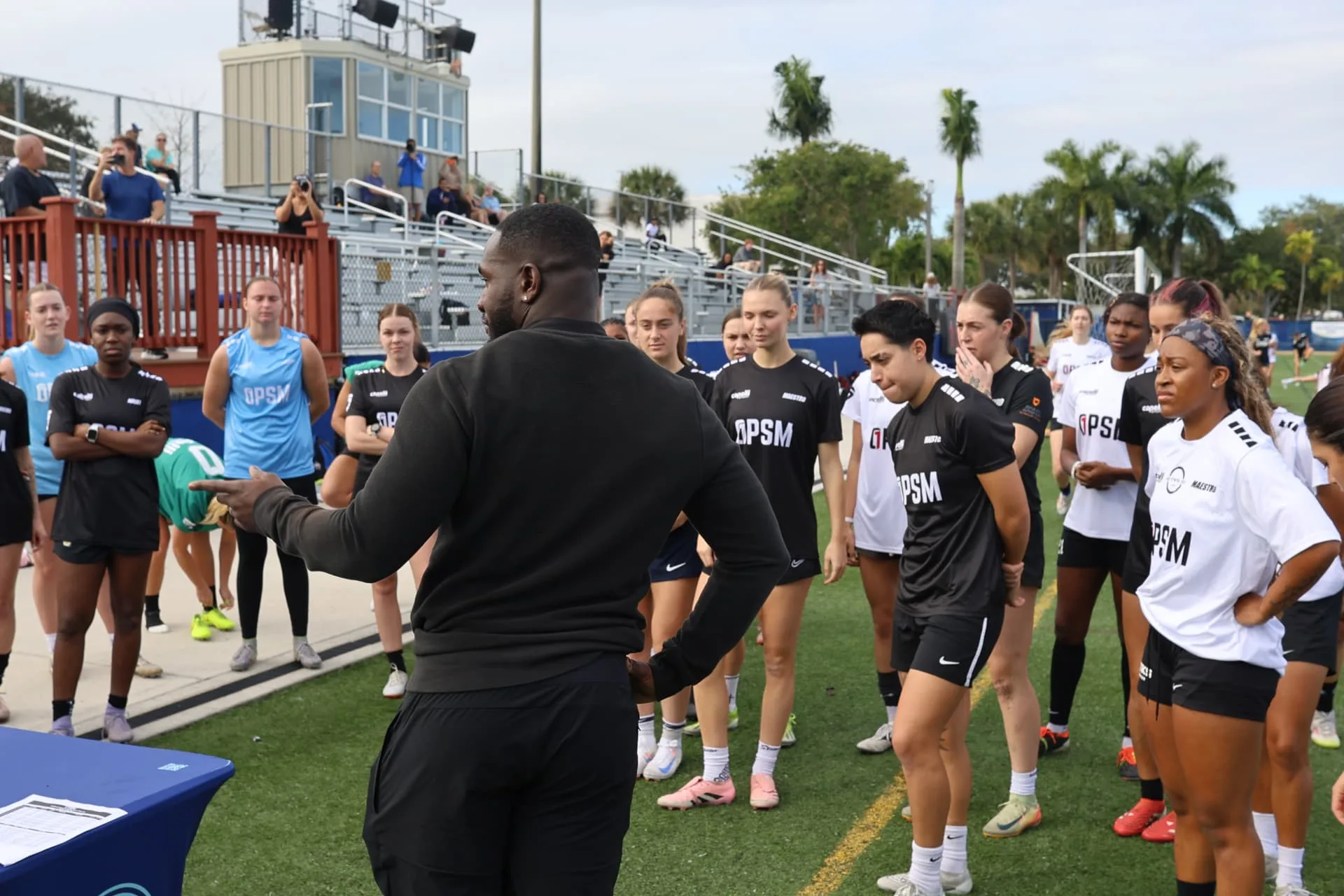 Coach addressing the full group of players before the session
