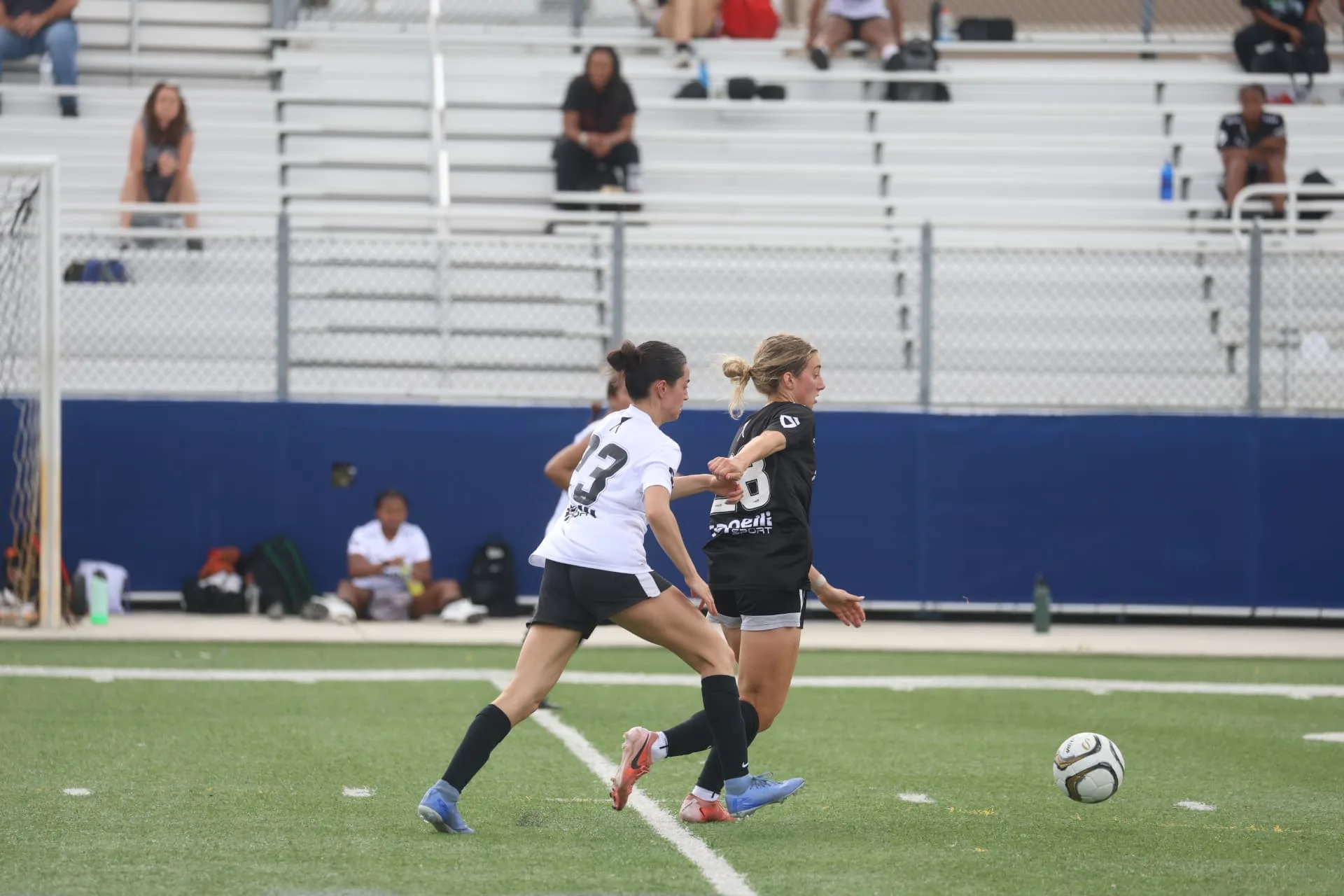 Attacker holding off a defender while chasing the ball