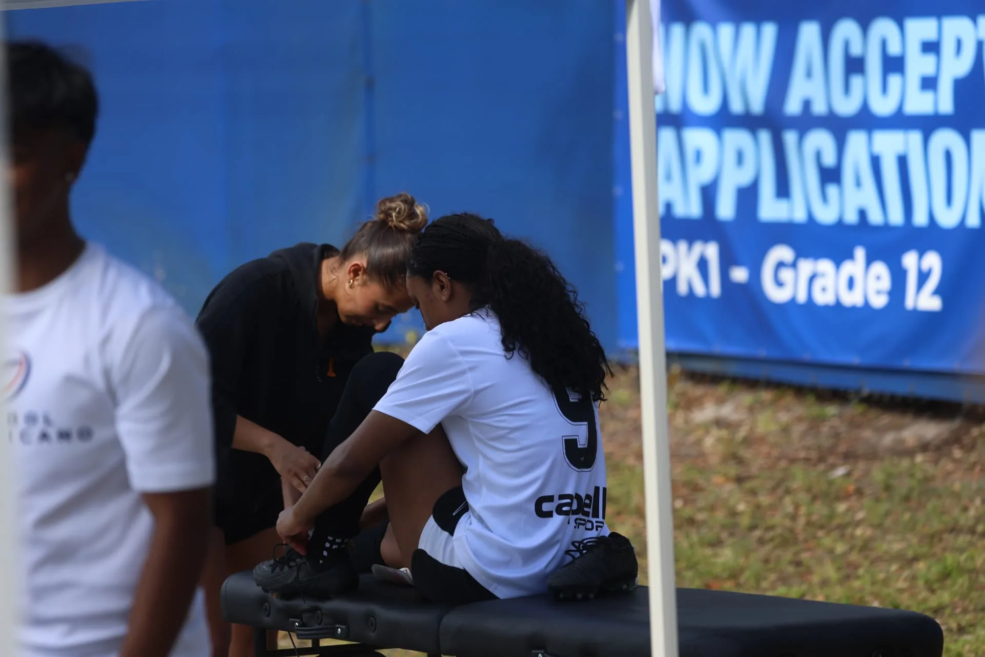 Athletic trainer taping a player's ankle on the sideline