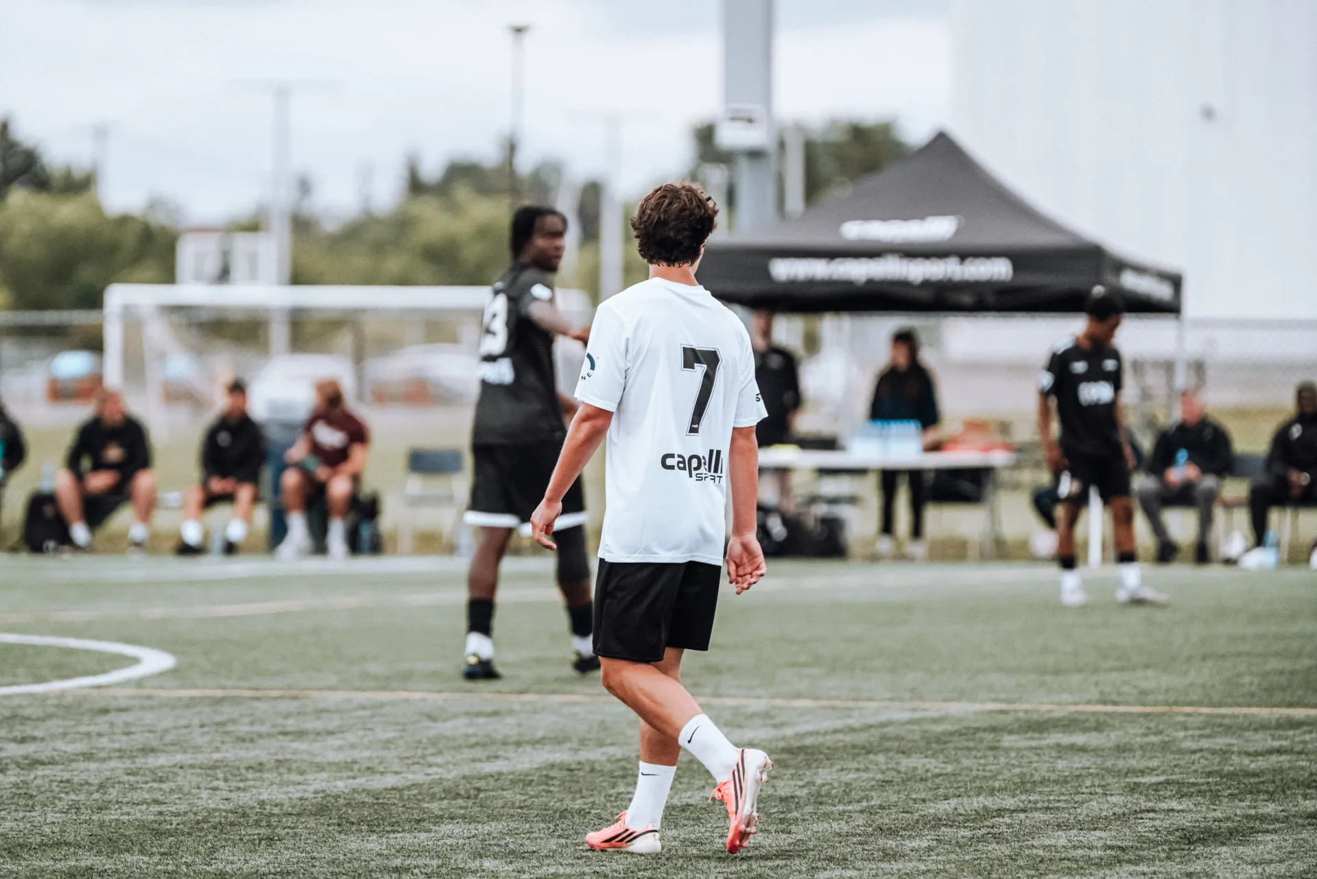 Player in white number 7 kit surveying the field