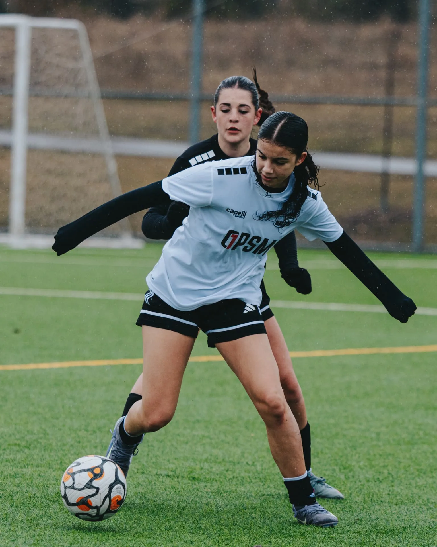 Attacker shielding the ball from a defender